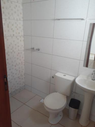 un bagno bianco con un water e un lavandino di Pousada Nascer da Lua a São Thomé das Letras