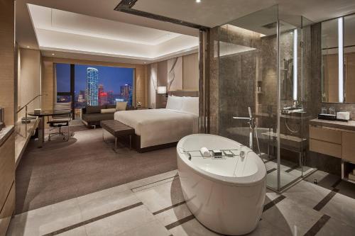 een hotelkamer met een bed en een bad bij JW Marriott Hotel Chengdu in Chengdu