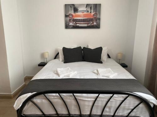 uma cama num quarto com uma fotografia de um carro em Garsoniera 27mp - Camera - Baie - Bucatarie - Balcon em Mogoşoaia