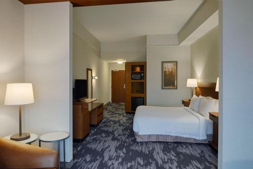 a hotel room with a bed and a couch at Fairfield Inn & Suites by Marriott Columbus Airport in Columbus