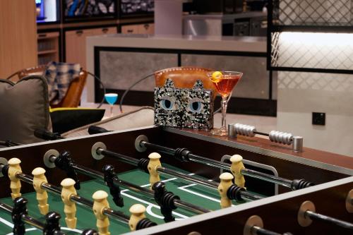 a drink and a glass sitting on top of a pool table at Moxy Manchester City in Manchester