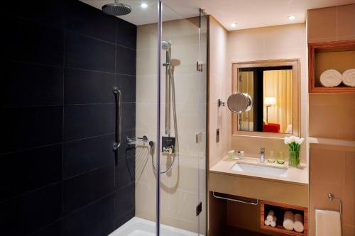 a bathroom with a shower and a sink at Courtyard by Marriott World Trade Center, Abu Dhabi in Abu Dhabi