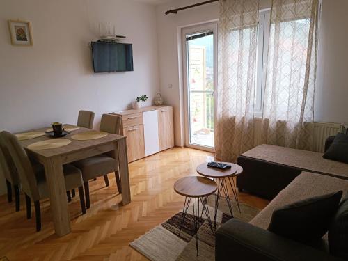 a living room with a table and a kitchen at Apartman HeLena in Soko Banja