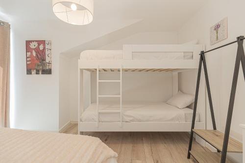 エリセイラにあるCasas Bernardesの二段ベッド2台とベッド1台が備わる客室です。