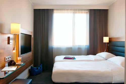 a hotel room with two beds and a large window at Moxy Berlin Ostbahnhof in Berlin