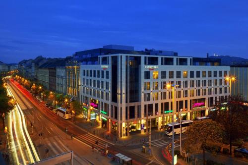 a large white building on a city street at night at Courtyard by Marriott Budapest City Center in Budapest