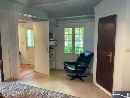 - un salon avec une chaise noire dans l'établissement Maisonnette proche de la mer, calme avec parking, à Angoulins-sur-Mer