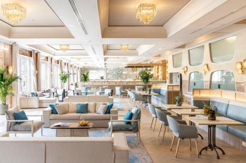 a restaurant with couches and tables and chairs at Delta Hotels by Marriott Giardini Naxos in Giardini Naxos