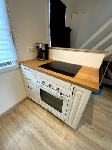 eine Küche mit einer Arbeitsplatte und einer Mikrowelle in der Unterkunft Charmante petite maison in Les Renardières