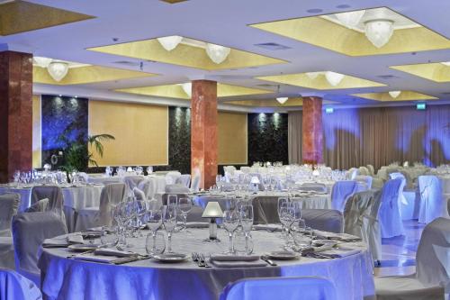 a large banquet hall with white tables and chairs at Delta Hotels by Marriott Giardini Naxos in Giardini Naxos