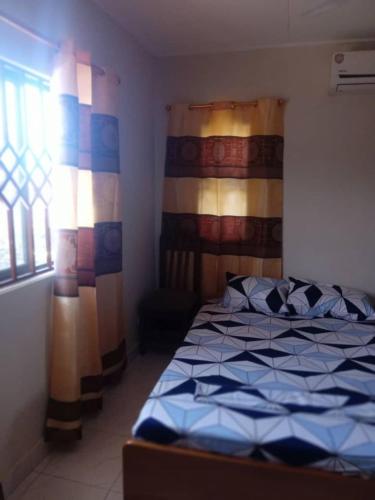 a bedroom with a bed in a room with a window at Spintex Villas - Available for Long Term Rentals in Ablekuma