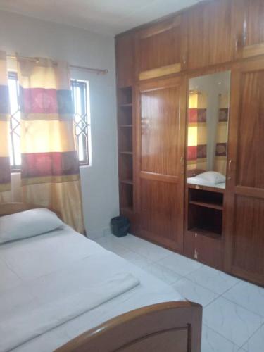 a bedroom with a bed and wooden cabinets at Spintex Villas - Available for Long Term Rentals in Ablekuma