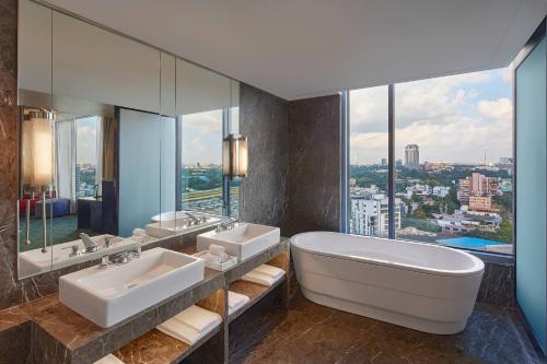 a bathroom with two sinks and a large mirror at Renaissance Bengaluru Race Course Hotel in Bangalore