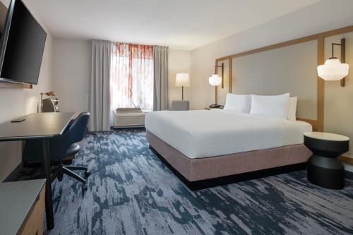 a hotel room with a bed and a desk at Fairfield Inn & Suites Denton in Denton