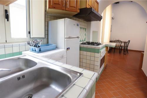 a kitchen with a sink and a white refrigerator at Il Portale 2 in Tropea