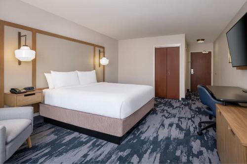 a hotel room with a large bed and a television at Fairfield Inn & Suites Denton in Denton