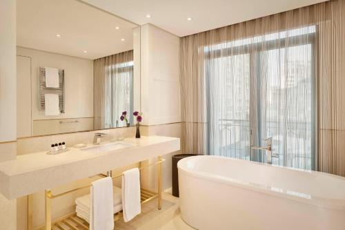 a bathroom with a tub and a sink and a mirror at The Alexander, a Luxury Collection Hotel, Yerevan in Yerevan