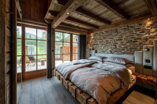 a bedroom with a stone wall and a large bed at LaPosch - Dein Bergaway in Biberwier