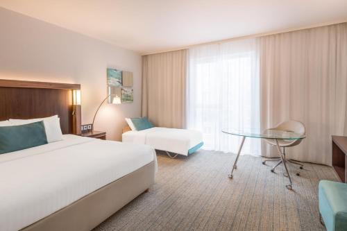 a hotel room with a bed and a glass table at Courtyard by Marriott Cologne in Cologne