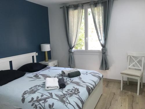 a bedroom with a bed with two towels and a window at Neptune in Cavalaire-sur-Mer