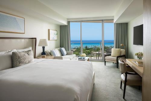 a hotel room with a bed and a view of the ocean at The Ritz-Carlton Residences, Waikiki Beach Hotel in Honolulu