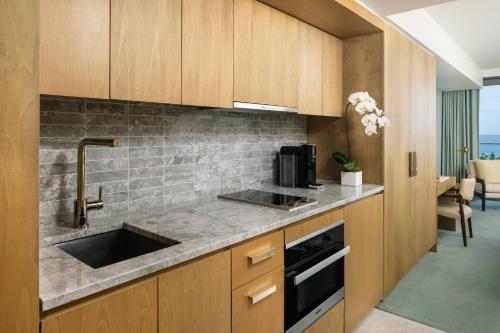 a kitchen with a sink and a microwave at The Ritz-Carlton Residences, Waikiki Beach Hotel in Honolulu