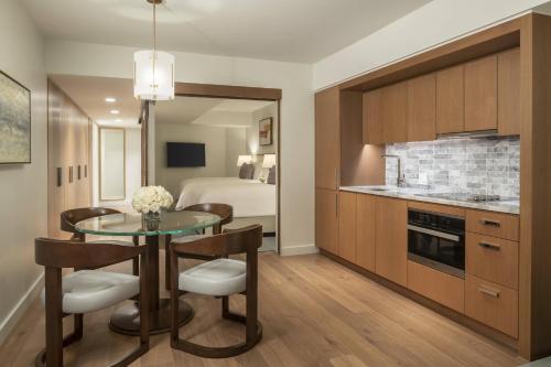a kitchen and dining room with a table and a bed at The Ritz-Carlton Residences, Waikiki Beach Hotel in Honolulu