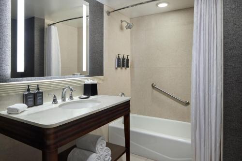 a bathroom with a sink and a tub and a mirror at Sheraton Valley Forge King of Prussia in King of Prussia