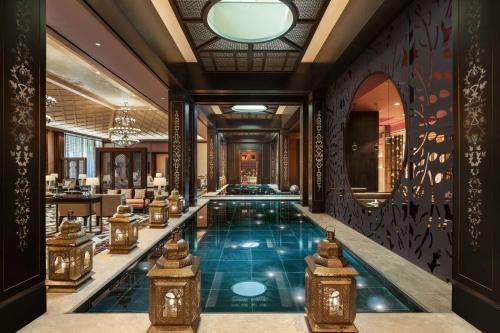 a hotel lobby with a pool and a bar at The St. Regis Cairo in Cairo