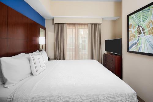 a hotel room with a large bed and a tv at Residence Inn by Marriott Houston Katy Mills in Katy