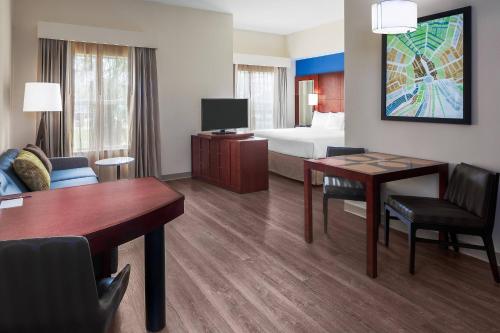 a hotel room with a bed and a desk and a room at Residence Inn by Marriott Houston Katy Mills in Katy