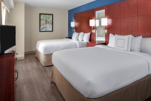a hotel room with two beds and a flat screen tv at Residence Inn by Marriott Houston Katy Mills in Katy
