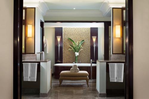 a bathroom with a tub and a bench and a sink at Sheraton Senggigi Beach Resort in Senggigi