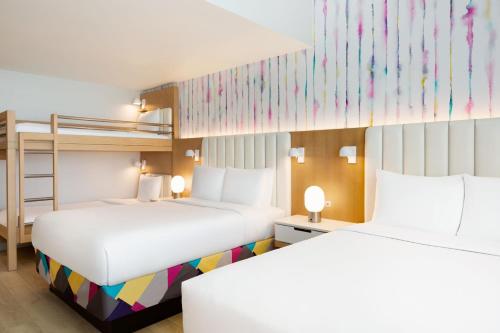 a bedroom with two beds and a bunk bed at The Viv Hotel, Anaheim, a Tribute Portfolio Hotel in Anaheim