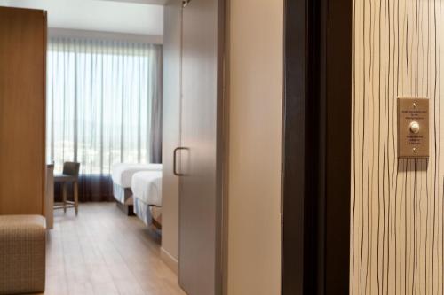 a door to a room with a bedroom and a bed at The Viv Hotel, Anaheim, a Tribute Portfolio Hotel in Anaheim