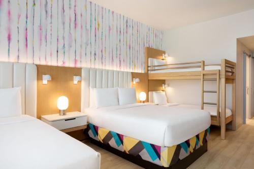 a bedroom with two beds and a bunk bed at The Viv Hotel, Anaheim, a Tribute Portfolio Hotel in Anaheim