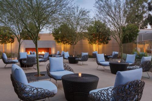 a patio with chairs and tables and a fire place at The Viv Hotel, Anaheim, a Tribute Portfolio Hotel in Anaheim