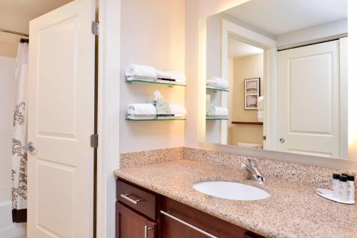 a bathroom with a sink and a mirror at Residence Inn by Marriott Coralville in Coralville