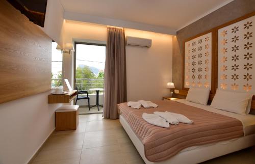 a bedroom with a bed and a balcony at Hotel Aghas Paleochora in Palaiochora
