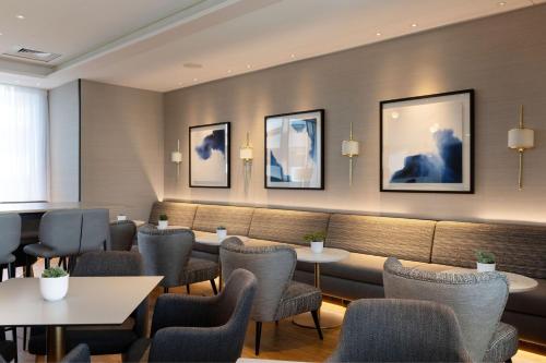a restaurant with tables and chairs and pictures on the wall at Sheraton Nice in Nice