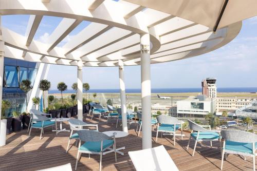 a patio with chairs and tables and a view of the ocean at Sheraton Nice in Nice