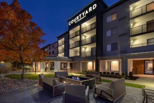 an exterior view of a hotel with chairs and a fire pit at Courtyard by Marriott Cincinnati Airport in Erlanger