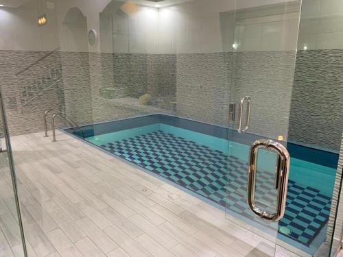una grande piscina con doccia in bagno di شاليه رست نايت - عرعر a Arar