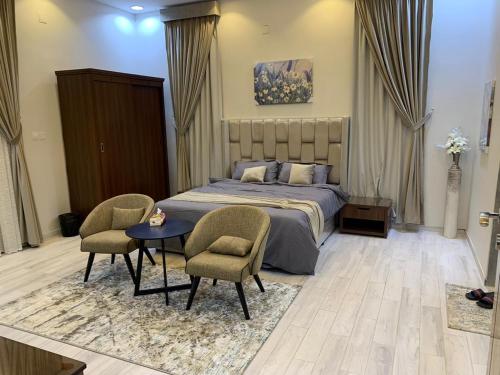 una camera con un letto e due sedie e un tavolo di شاليه رست نايت - عرعر a Arar
