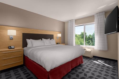 a hotel room with a large bed and a flat screen tv at TownePlace Suites by Marriott Charleston Mt. Pleasant in Charleston