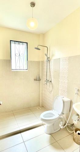 a bathroom with a toilet and a shower and a sink at Villa Macheo in Mombasa