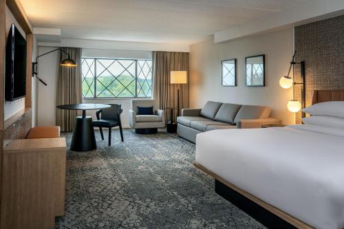 a hotel room with a bed and a couch and a table at Sheraton Nashua in Nashua