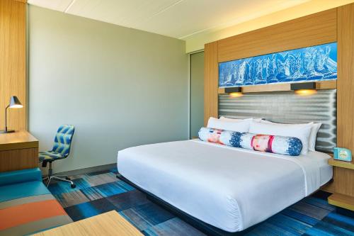 プラノにあるAloft Hotel Planoのベッドルーム(大きな白いベッド1台、椅子付)