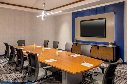 a conference room with a large table and a flat screen tv at Sheraton Nashua in Nashua