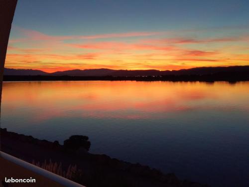 un coucher de soleil sur une grande étendue d'eau dans l'établissement TRÈS BELLE VUE, à Leucate
